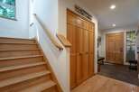 Step into this inviting entryway featuring a beautiful wooden staircase and ample storage with built-in closets.