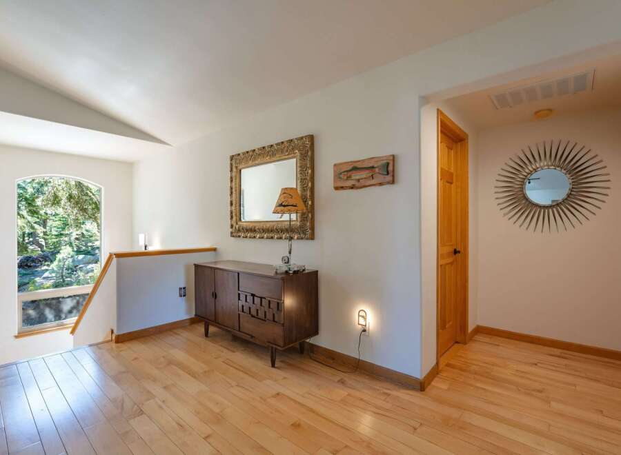 This charming entryway features a beautiful arched window offering serene views of the surrounding nature.