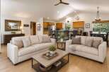Experience open-concept living in this beautifully appointed home, featuring a spacious living area that seamlessly flows into a modern kitchen with a breakfast bar.