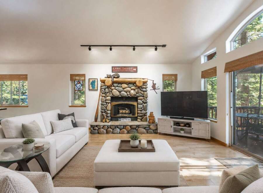 Experience cozy living in this inviting living room, featuring a stunning stone fireplace as the centerpiece.