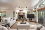 Experience cozy living in this inviting living room, featuring a stunning stone fireplace as the centerpiece.