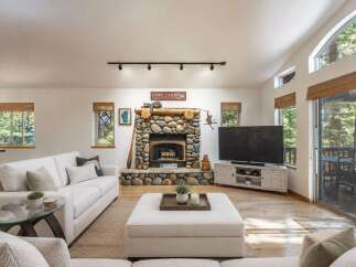 Experience cozy living in this inviting living room, featuring a stunning stone fireplace as the centerpiece.