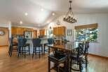 This spacious kitchen and dining area features a vaulted ceiling with recessed lighting and a rustic chandelier.