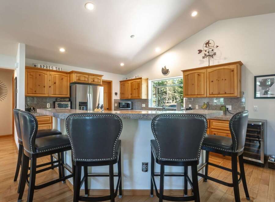 This spacious kitchen features a large granite island with comfortable seating, perfect for casual dining or entertaining guests.