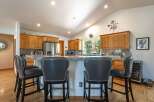 This spacious kitchen features a large granite island with comfortable seating, perfect for casual dining or entertaining guests.