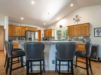 This spacious kitchen features a large granite island with comfortable seating, perfect for casual dining or entertaining guests.