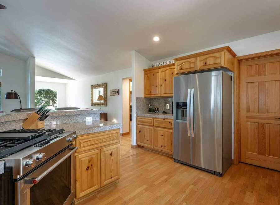 This spacious kitchen features a professional-grade stainless steel gas range and a large side-by-side refrigerator, perfect for any home chef.