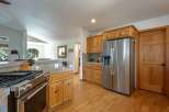 This spacious kitchen features a professional-grade stainless steel gas range and a large side-by-side refrigerator, perfect for any home chef.
