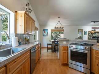 Discover this charming kitchen featuring warm wood cabinetry and granite countertops, perfect for culinary adventures.