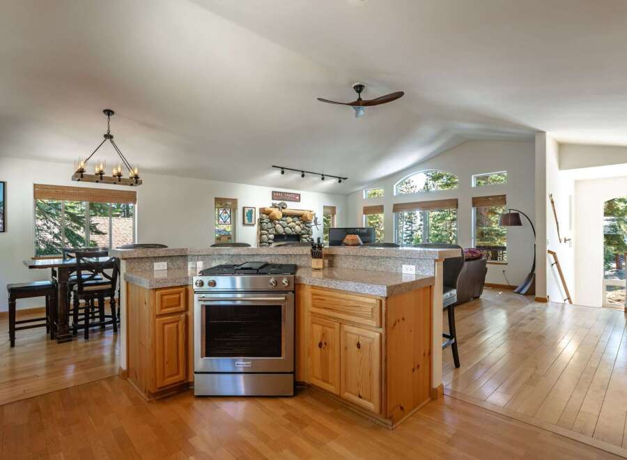 Experience the perfect blend of comfort and style in this spacious open-concept living area, featuring a modern kitchen island with a built-in range and ample counter space.