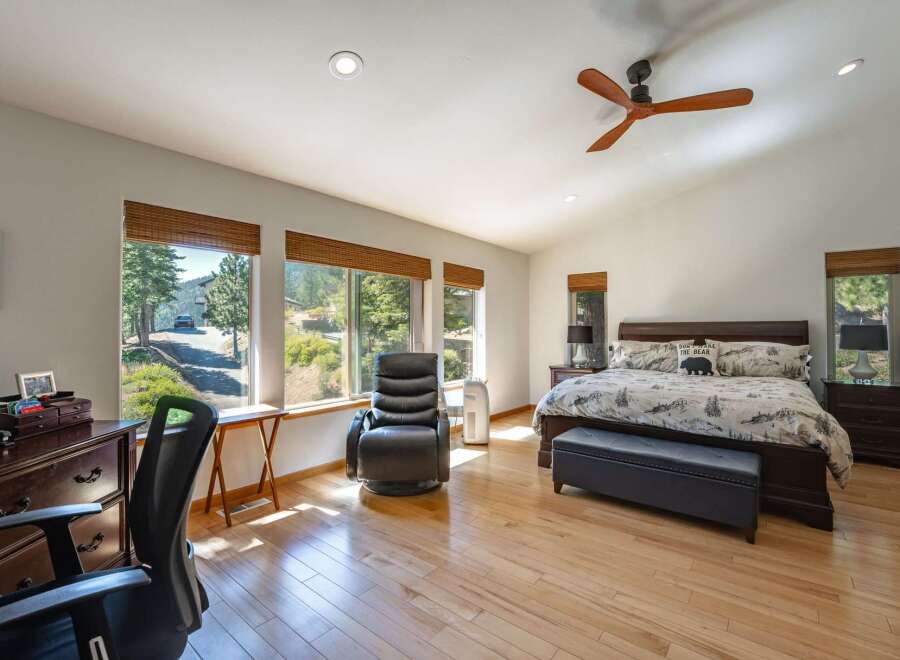 Experience serene living in this spacious bedroom, featuring large windows that flood the room with natural light and offer picturesque views of the surrounding landscape.