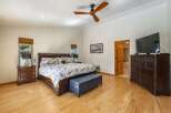 Experience ultimate comfort in this spacious master bedroom, featuring a luxurious king-size bed with charming bear-themed pillows and a plush ottoman at the foot of the bed.
