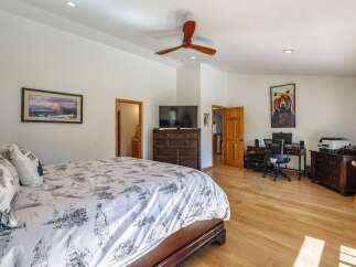 This spacious bedroom features a comfortable king-size bed with a nature-inspired duvet and a large dresser with an integrated TV.