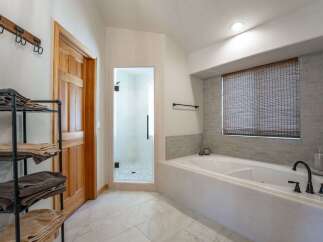 Experience luxury in this stunning bathroom featuring a spacious soaking tub and a separate glass-enclosed shower.