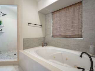 Indulge in relaxation in this luxurious bathroom featuring a spacious jetted tub perfect for unwinding after a long day.