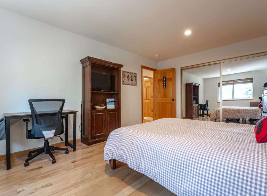 This bedroom features a comfortable queen-sized bed with a charming gingham duvet, perfect for a restful night's sleep.