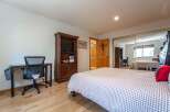 This bedroom features a comfortable queen-sized bed with a charming gingham duvet, perfect for a restful night's sleep.