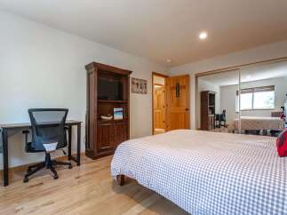 This bedroom features a comfortable queen-sized bed with a charming gingham duvet, perfect for a restful night's sleep.