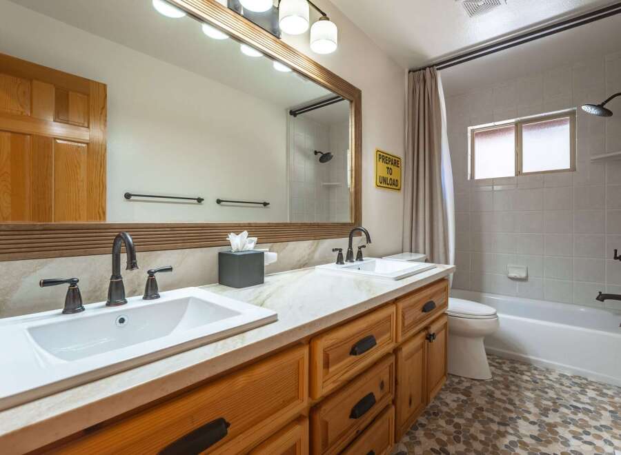 This charming bathroom features a spacious double vanity with ample counter space and storage, perfect for busy mornings.