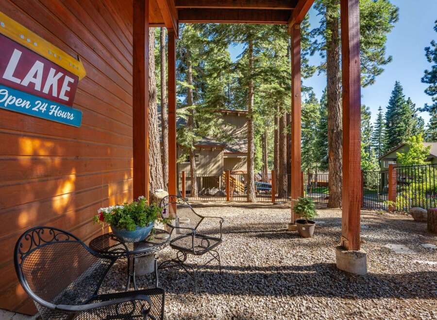 Enjoy the serene mountain setting from this charming porch, complete with rustic wooden beams and a cozy seating area.