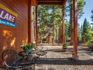 Enjoy the serene mountain setting from this charming porch, complete with rustic wooden beams and a cozy seating area.