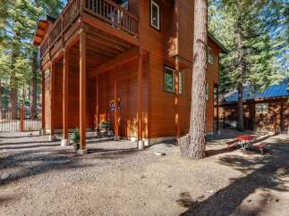 Experience the charm of this rustic wooden home nestled amongst tall pine trees.