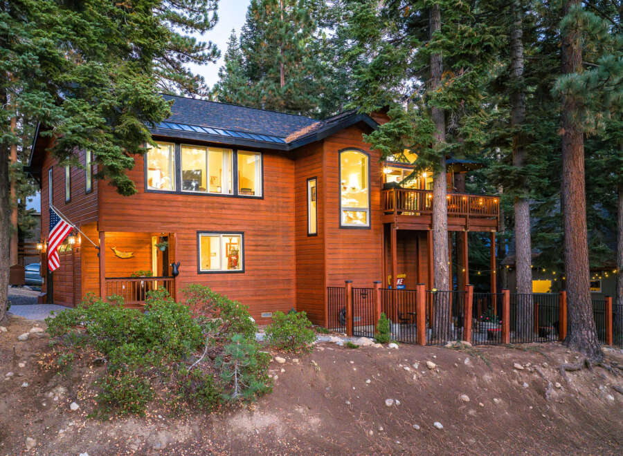 Nestled among tall pine trees, this charming wooden home offers a warm and inviting atmosphere.