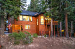 Nestled among tall pine trees, this charming wooden home offers a warm and inviting atmosphere.