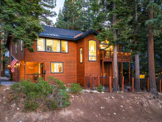 Nestled among tall pine trees, this charming wooden home offers a warm and inviting atmosphere.