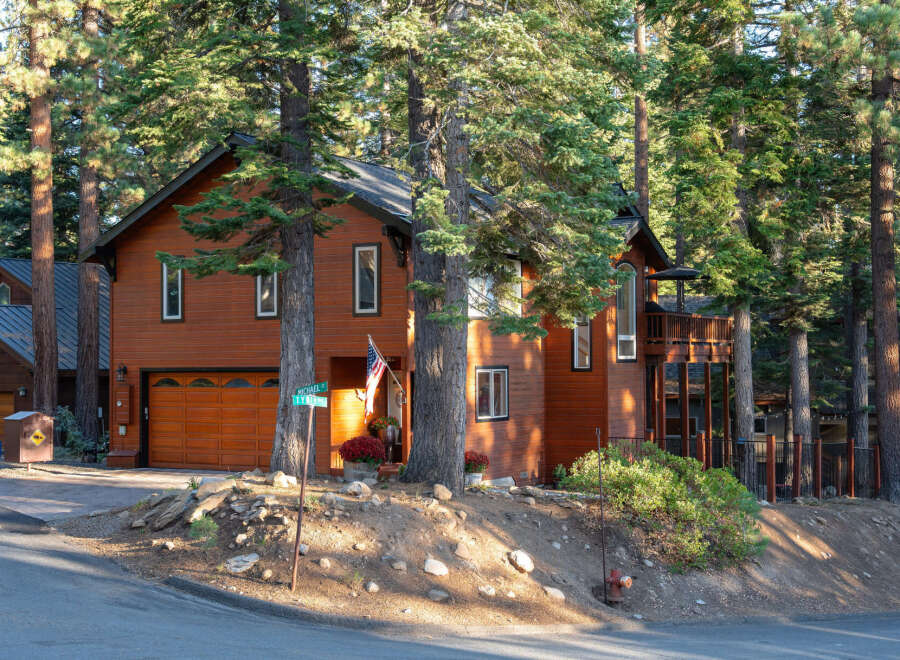 Nestled among tall pine trees, this charming wooden home offers a warm and inviting atmosphere.