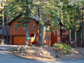 Nestled among tall pine trees, this charming wooden home offers a warm and inviting atmosphere.