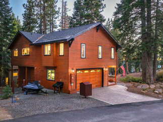 Experience mountain living in this stunning wood-sided home, nestled amongst tall pine trees.