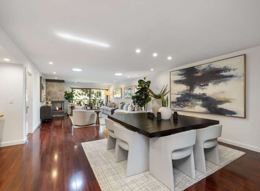 Experience modern living in this spacious open-concept home, featuring a sleek fireplace and a large abstract artwork that anchors the dining area.