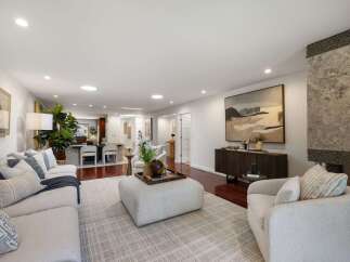Experience modern living in this spacious open-concept living area, featuring a comfortable sectional sofa and a stylish ottoman perfect for gatherings.