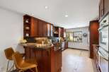 This stunning kitchen boasts rich cherry wood cabinetry and a sleek granite countertop, perfect for culinary enthusiasts.