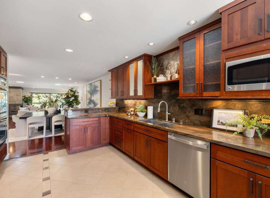 Discover this stunning kitchen featuring rich cherry wood cabinetry and elegant granite countertops.