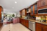 Discover this stunning kitchen featuring rich cherry wood cabinetry and elegant granite countertops.