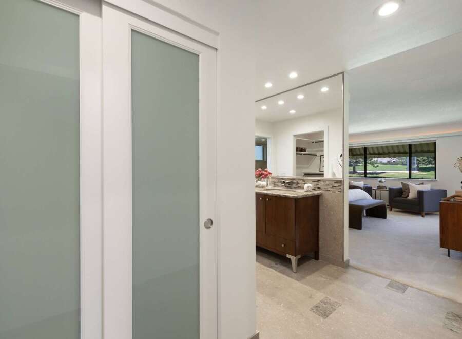 Step into a beautifully appointed bathroom featuring a sleek vanity and a mirrored wall that enhances the sense of space.