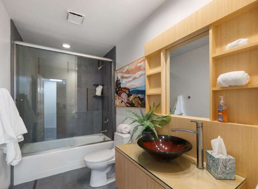 Experience modern luxury in this stunning bathroom featuring a sleek glass-enclosed shower and a deep soaking tub, perfect for unwinding.