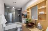 Experience modern luxury in this stunning bathroom featuring a sleek glass-enclosed shower and a deep soaking tub, perfect for unwinding.