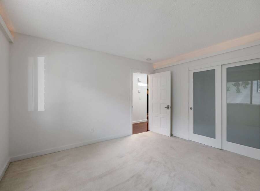 Step into this bright and airy bedroom, featuring plush carpeting and a clean, neutral color palette.