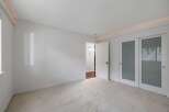Step into this bright and airy bedroom, featuring plush carpeting and a clean, neutral color palette.