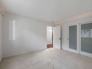 Step into this bright and airy bedroom, featuring plush carpeting and a clean, neutral color palette.
