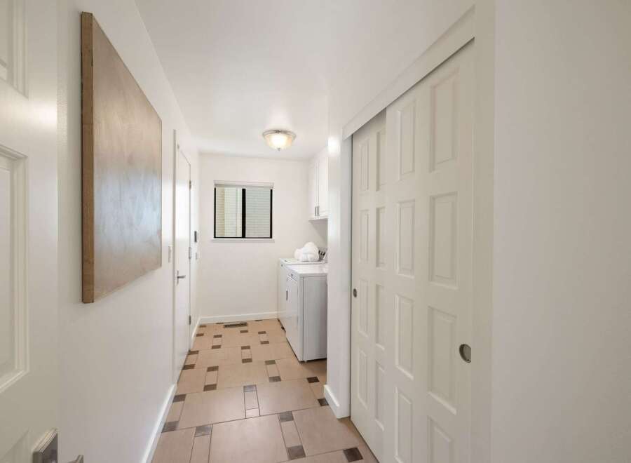 Discover a bright and airy hallway featuring a convenient laundry area with a washer and dryer.