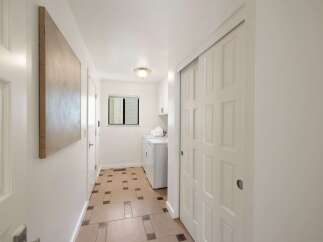 Discover a bright and airy hallway featuring a convenient laundry area with a washer and dryer.