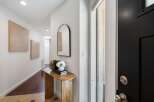 Step into a welcoming entryway featuring a sleek black door and a stylish arched mirror.