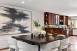 Elevate your dining experience in this sophisticated space, featuring a striking abstract artwork and a dark wood dining table perfect for intimate gatherings.