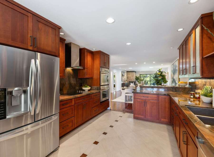 Experience luxury in this stunning kitchen featuring rich cherry wood cabinetry and sleek stainless steel appliances.