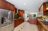 Experience luxury in this stunning kitchen featuring rich cherry wood cabinetry and sleek stainless steel appliances.