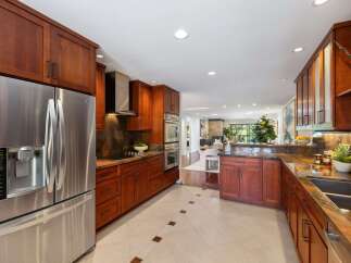 Experience luxury in this stunning kitchen featuring rich cherry wood cabinetry and sleek stainless steel appliances.
